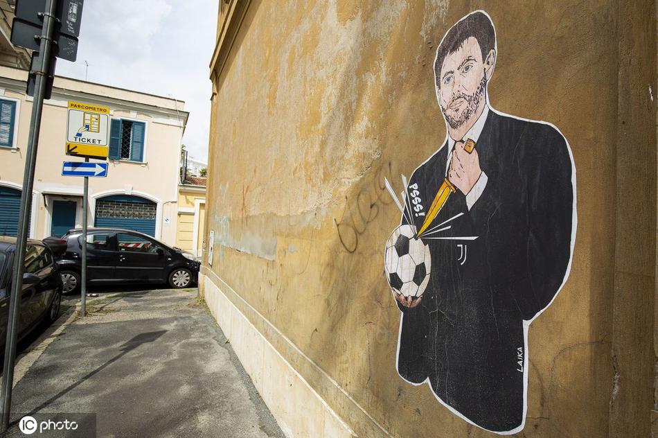 一位头发花白的老人推着自行车经过壁画，他微微侧头，目光落在被刺穿的足球上，脸上交织着困惑与忧伤，背景是罗马春日柔和的阳光，平凡生活与激烈抗议在此刻形成奇特的和谐。