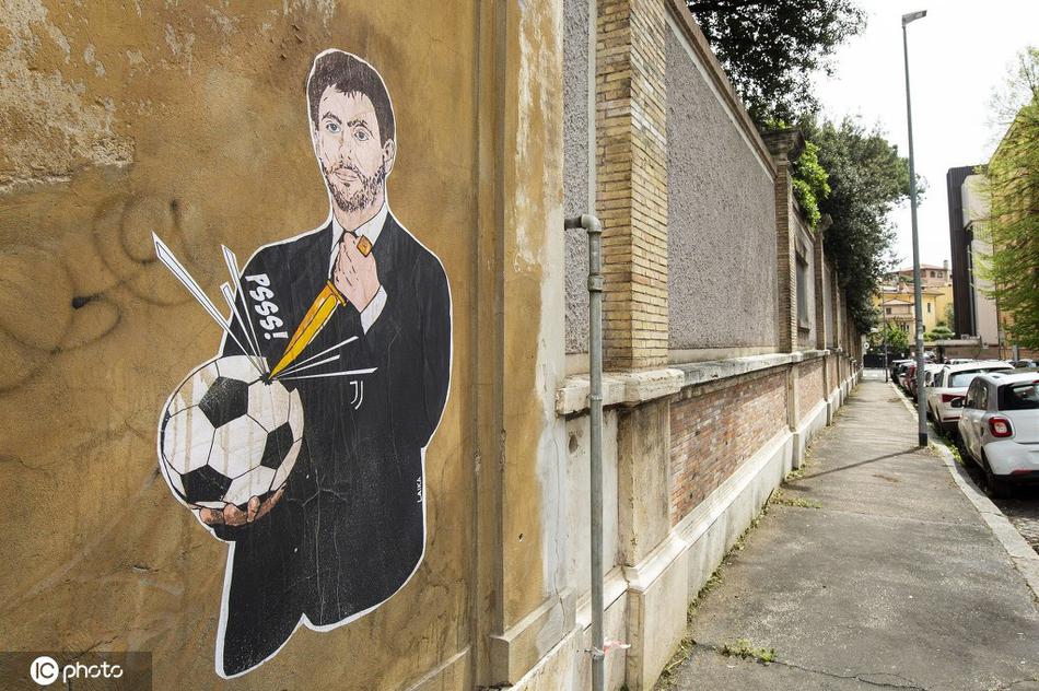 夕阳西下，金色的余晖洒在斑驳的墙面上，整幅壁画被笼罩在一层温暖而忧伤的光晕中，那只被刺破的足球在光影中格外醒目，仿佛在提醒每一个路过的人：有些伤口，即使愈合也会留下疤痕。