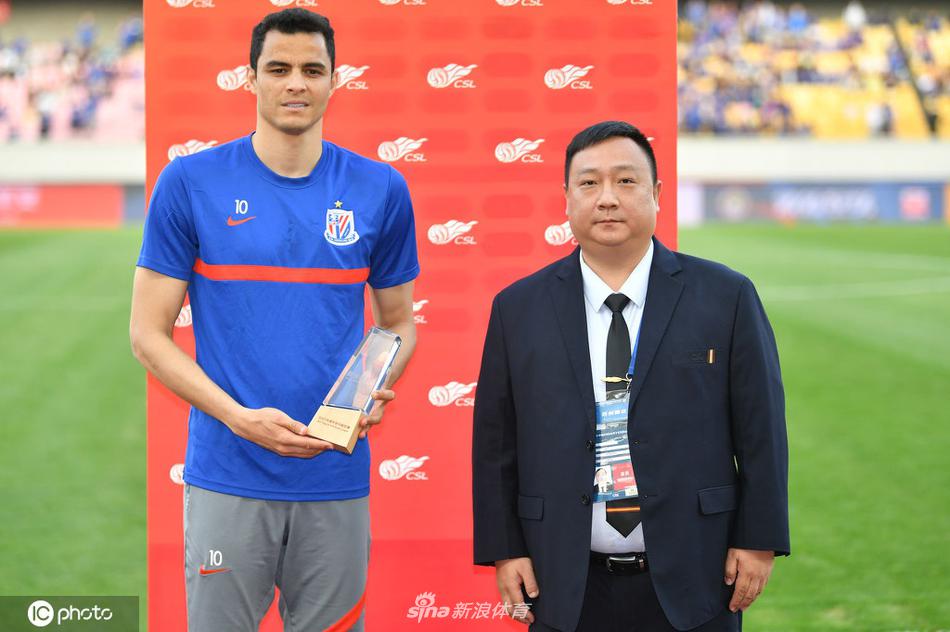 在灯火通明的江阴体育中心，莫雷诺身披深蓝色申花战袍，张开双臂激情奔跑庆祝进球，他身后的看台上，蓝色的旗帜翻涌如海啸般欢腾，整个画面充满了力量感与澎湃的激情。