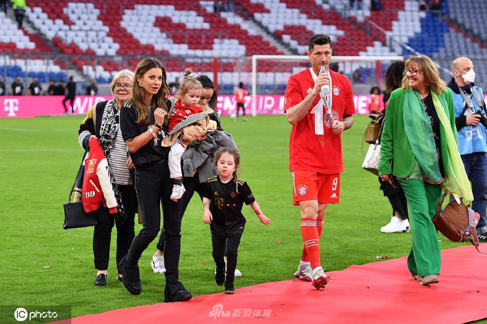 莱万抱着女儿指向庆祝现场，在她耳边温柔低语，父女间的温馨互动令人动容