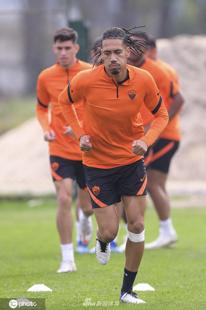 一名球员正在进行个人带球绕杆训练，他脚下的皮球仿佛被无形的线牵引着，动作行云流水，专注的眼神里透露出对胜利的渴望。