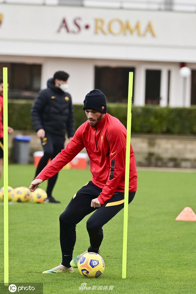 夕阳西下，一名罗马球员在训练结束后独自加练射门，皮球如出膛的炮弹般飞向球网，远处的围栏上，俱乐部的旗帜正随风猎猎作响。