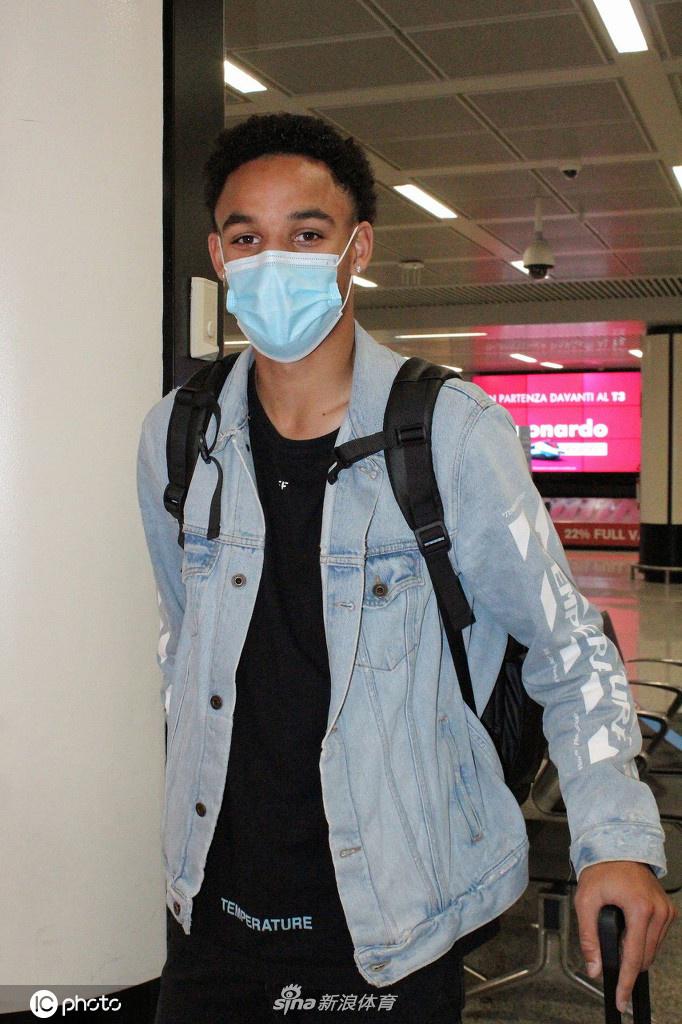 在室内光线柔和的背景下，雷诺兹侧身望向镜头，轮廓分明。他穿着休闲的白色T恤，显得干净利落，此刻的他或许正在脑海中勾勒自己首次踏上罗马训练基地特里戈里亚的画面。