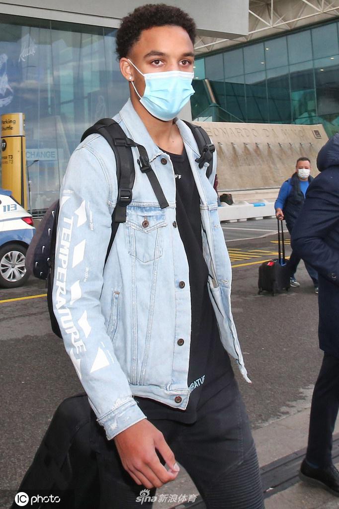 雷诺兹在一根罗马街头的石柱旁驻足，神情若有所思。他穿着黑色的外套和白色运动鞋，整个人的状态轻松又略带严肃，仿佛在思考即将开始的意甲征程会带给他怎样的磨砺与荣耀。