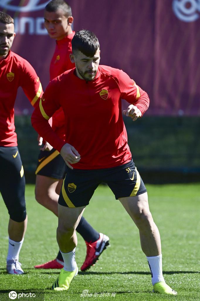 克里斯坦特双手叉腰，凝望着远处的训练设施，夕阳的余晖在他身上勾勒出一道金色的轮廓