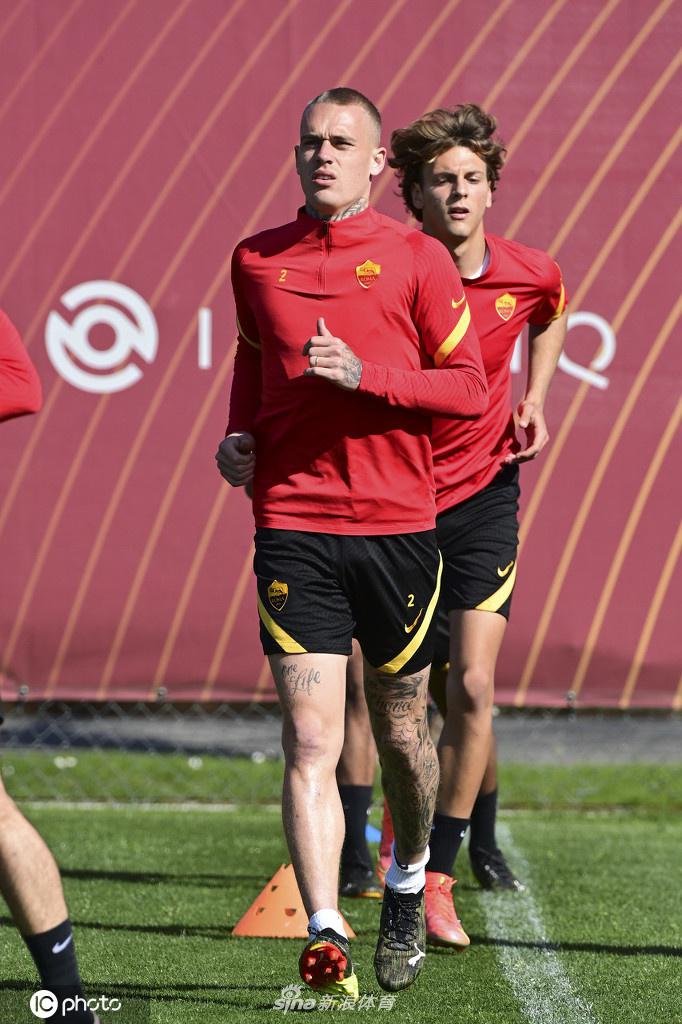 罗马前锋接队友边路传中，高高跃起准备头球攻门，他的身体在空中舒展开来，背景是湛蓝的天空和训练场的绿草，画面极具动感与美感。