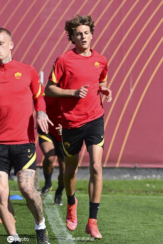 罗马队长在阳光下带队慢跑，眼神坚毅地望向远方，身后的队友们排成整齐的队列，步伐稳健地踏上训练草坪，仿佛一支即将出征的狼群。