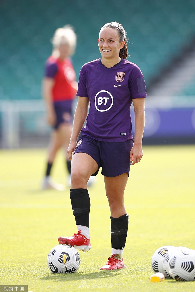 队长袖标在阳光下格外醒目，一名英格兰球员正在全神贯注地聆听教练的战术部署，坚定的眼神中透露出领袖的担当。