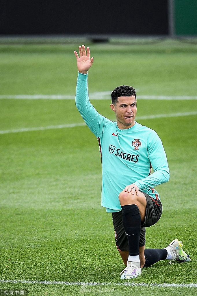 C罗在训练中主罚任意球，他紧抿嘴唇目光如炬地凝视着人墙后的球门，身体姿态充满力量。