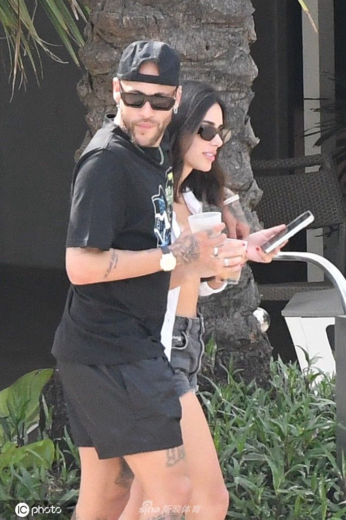 内马尔赤膊与友人在沙滩上进行排球比赛，他腾空跃起，神情专注，展现了运动员的好胜心与活力。