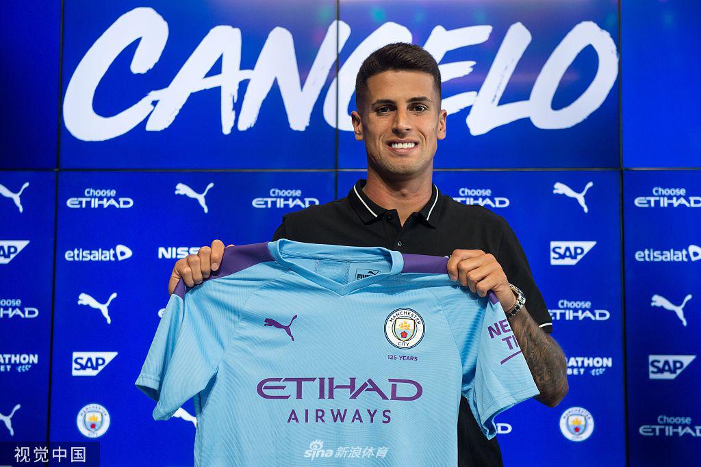 坎塞洛高举曼城27号战袍，眼神中闪烁着对未来英超征程的无限憧憬与坚定信念。