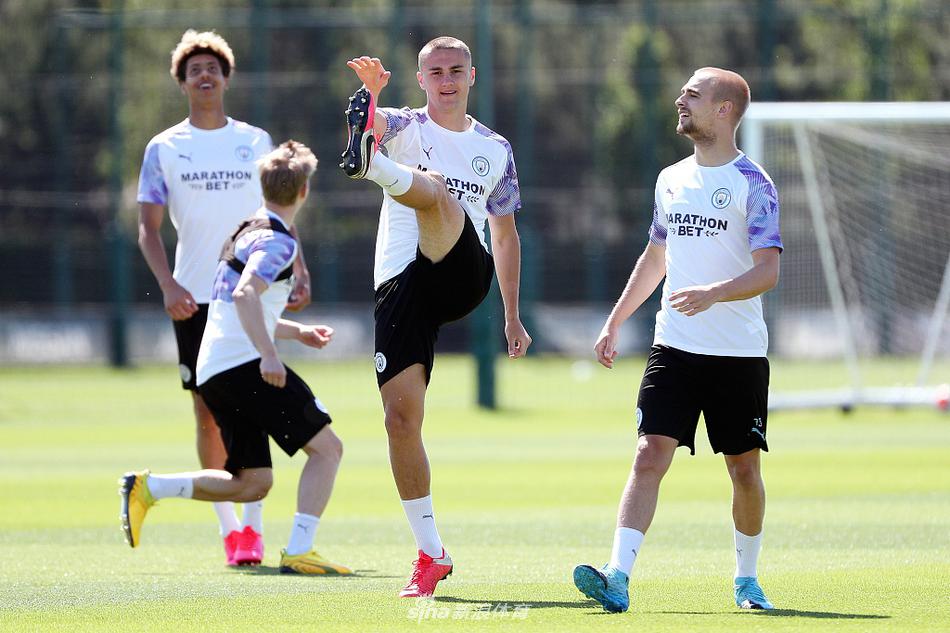 中后场球员们在教练组指导下进行传控演练，京多安抬头观察队友跑位，整个训练场被夕阳染成金色，团队的默契在这一刻无声传递。