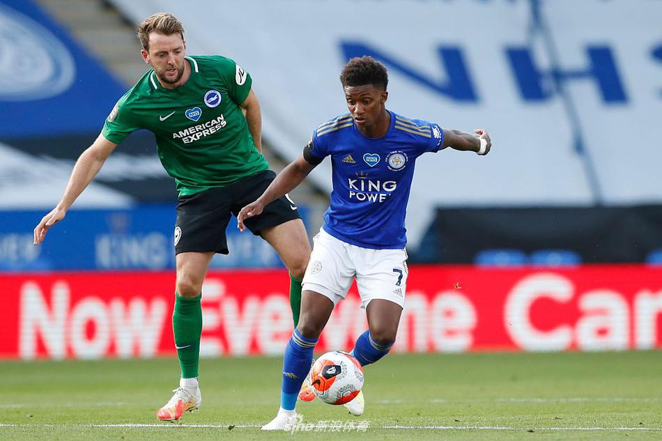 莱斯特城核心麦迪逊在三人包夹下依然试图转身突破，他脚下的足球仿佛被磁铁吸附，球衣因激烈的拉扯而扭曲，背景中模糊的广告牌与专注的防守队员脸庞，构成了中场博弈的微观缩影。