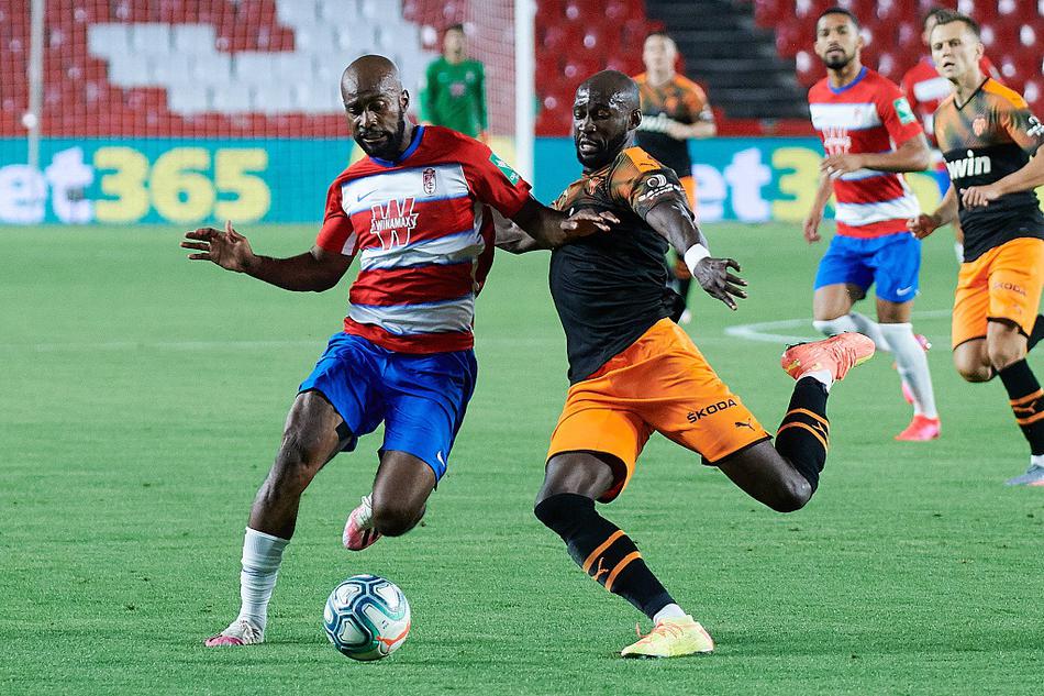 瓦伦西亚球员马努·巴列霍进球后激情滑跪，双臂张开，脸上洋溢着释放压力的狂喜，队友正朝他奔来