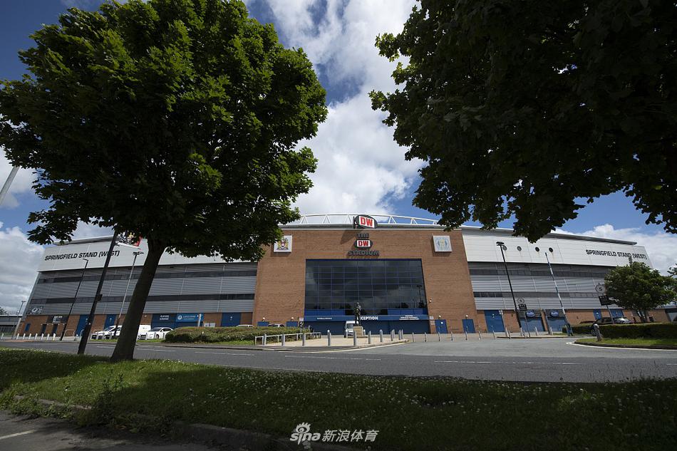 从球员通道入口望向场内，一排排座椅在空旷的看台上延展开来，替补席的塑料座椅在阳光下泛着温润的光泽，整个球场寂静得仿佛能听见草叶呼吸的声音。