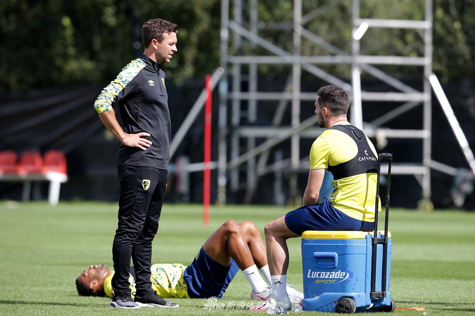 教练组正围在白板前激烈讨论，廷德尔用手势向球员们比划着新的战术体系，身后的球员们神情专注，认真聆听新赛季的战略部署