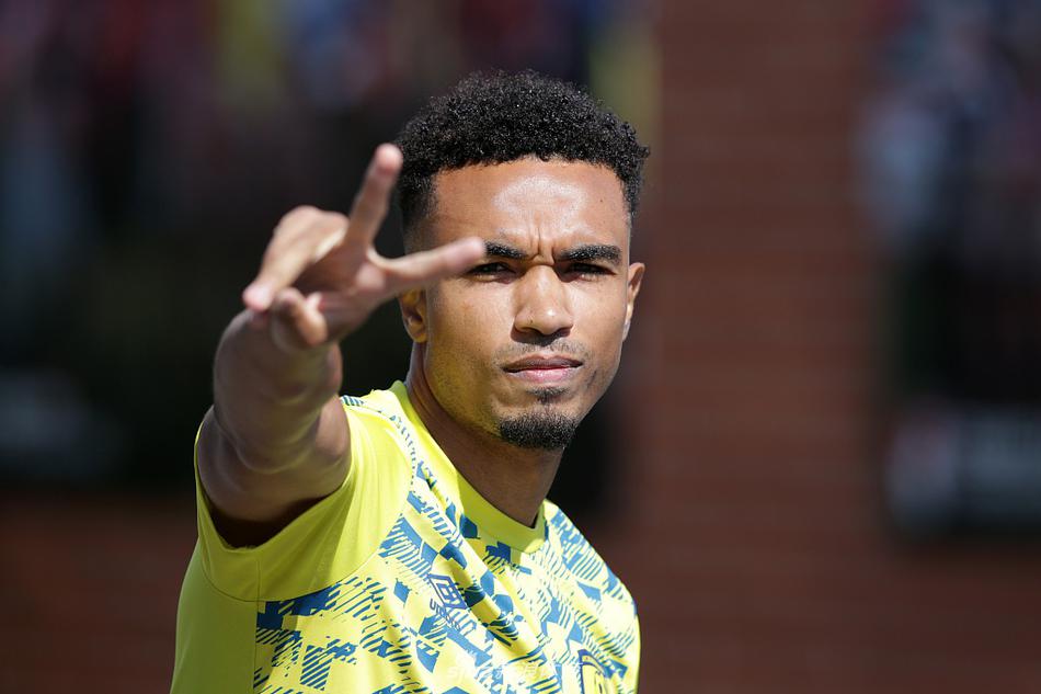 守门员在教练的指导下进行着高难度的扑救练习，他舒展的身体如同一张拉满的弓，身后的球门在阳光下投下长长的影子，仿佛象征着需要守护的荣耀