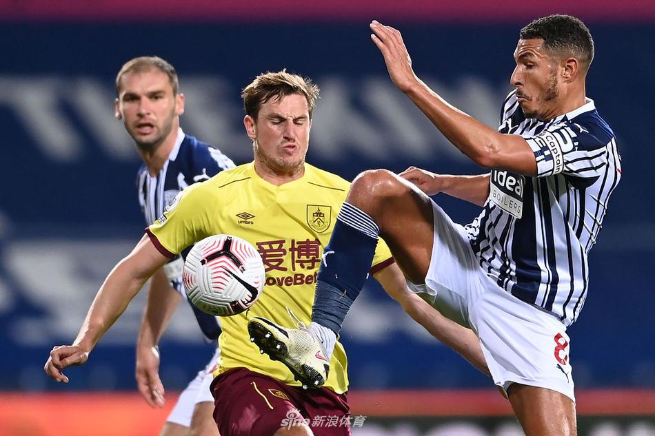 山楂球场夜幕下，西布朗球员带球突破，眼神专注试图撕开伯恩利严密防线