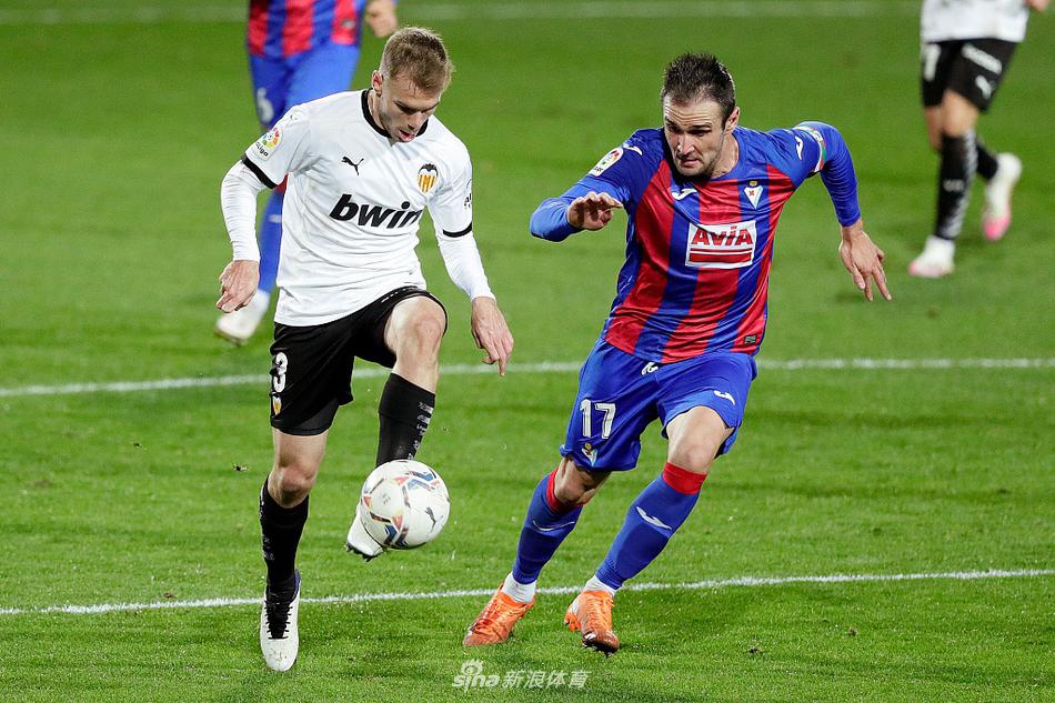 埃瓦尔前锋基克在瓦伦西亚禁区内背身拿球，试图转身突破，防守球员贴身紧逼
