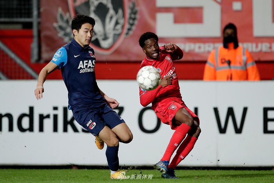 日本后卫菅原由势在进球后握拳怒吼，脸上带着自信与坚毅的表情，队友纷纷上前摸头庆祝，见证他为球队立下的汗马功劳。