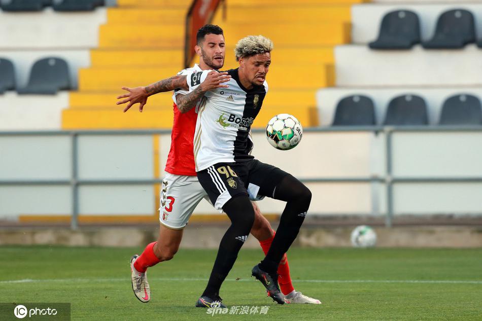 布拉加主帅卡瓦哈尔在场边神情严峻地指挥着比赛，他右手握拳，左手做出战术手势，试图让球队顶住主队的猛攻，并寻找反击的机会，他身后的教练组成员同样紧张地注视着场内。