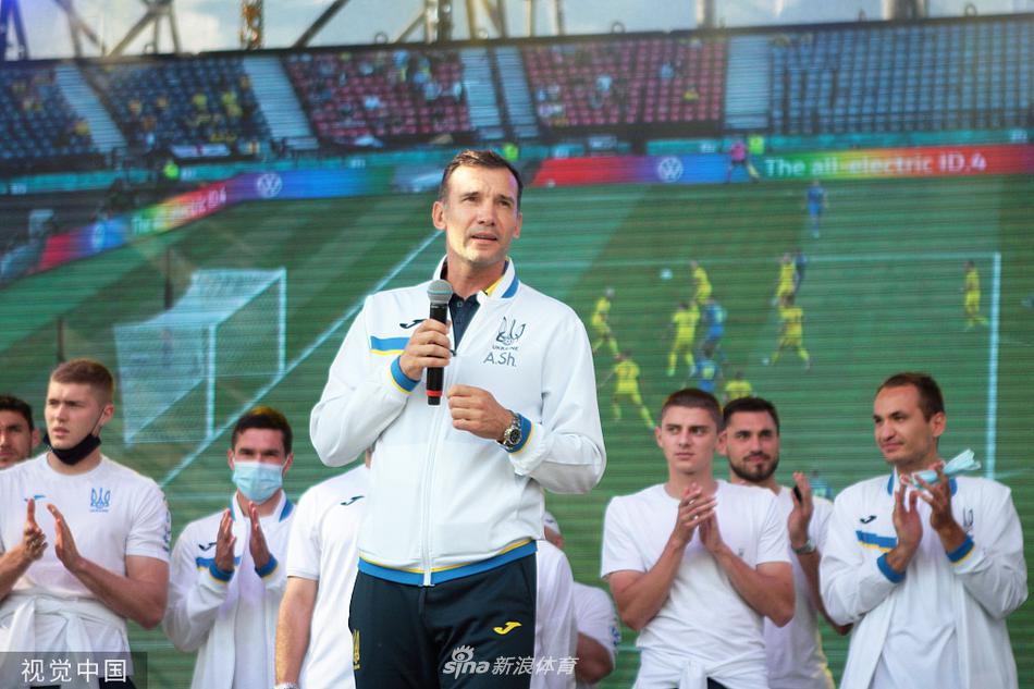 球员们手捧鲜花穿过停机坪，灿烂的阳光洒在他们轻松的笑脸上，走在最前面的球员正低头凝视着这份来自祖国人民的真挚感谢。