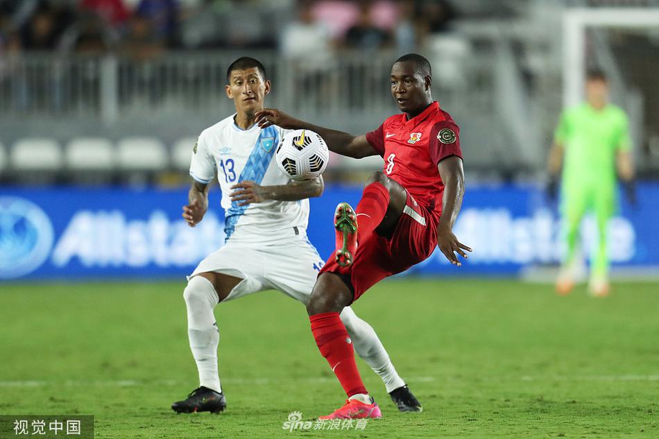 瓜德罗普队员在进球后激情拥抱庆祝，背景是看台上失落的危地马拉球迷，冰火两重天。