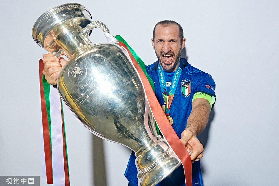 队长基耶利尼咧嘴大笑，眼角的皱纹里都藏着喜悦，他高高举起金光闪闪的欧洲杯冠军奖杯，仿佛要将53年的等待与此刻的荣耀一同举向天空。