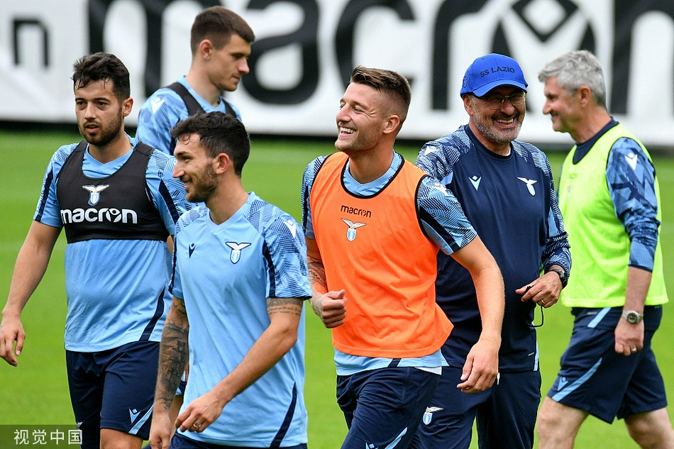 尽管天空飘着细雨，拉齐奥的球员们依旧热情高涨，他们围拢在一起进行抢圈热身。蓝色的训练服在山野间格外醒目，笑声与呼喊声预示着团队氛围的融洽。