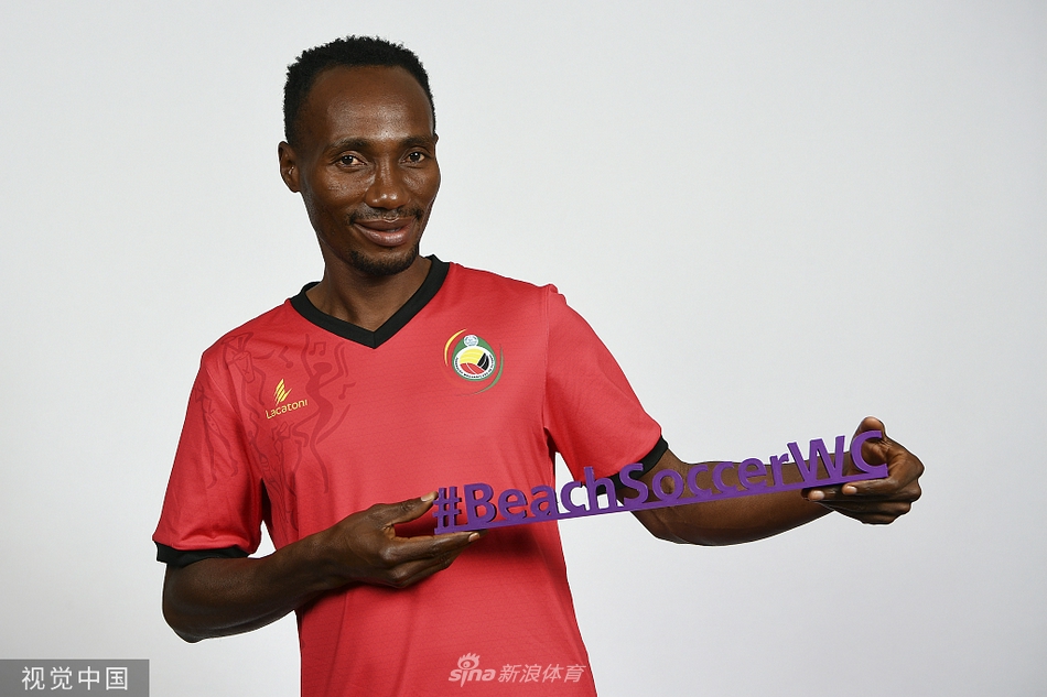 门将曼努埃尔目光坚毅，双手稳稳抱住沙滩足球，金色的沙粒沾在他的手臂上，仿佛身披的铠甲