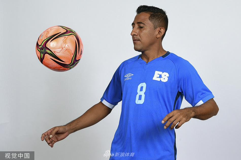 训练间隙，两名球员肩并肩坐在沙滩上，背景是简洁的球门框架。他们轻松地交谈着，笑纹爬上眼角，与脚下细腻的沙粒融为一体，展现出大战前夕难得的放松与兄弟情谊。