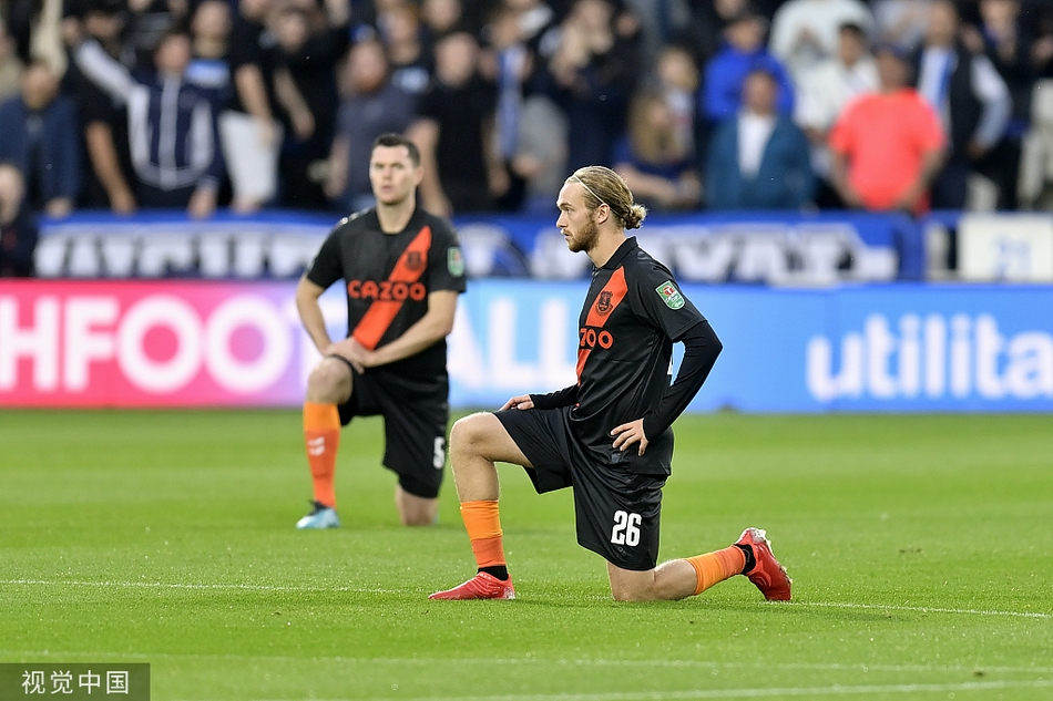 哈德斯菲尔德球员在禁区内争顶头球，埃弗顿防守球员贴身紧逼，双方在空中展开激烈对抗，球衣拉扯，肌肉紧绷，比赛的紧张程度可见一斑