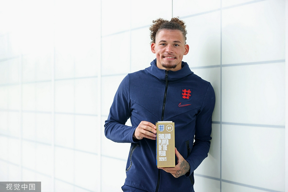 卡尔文·菲利普斯在训练中面露微笑，手捧刚刚获得的英格兰年度最佳球员奖杯，眼中闪烁着惊喜与自豪的光芒。
