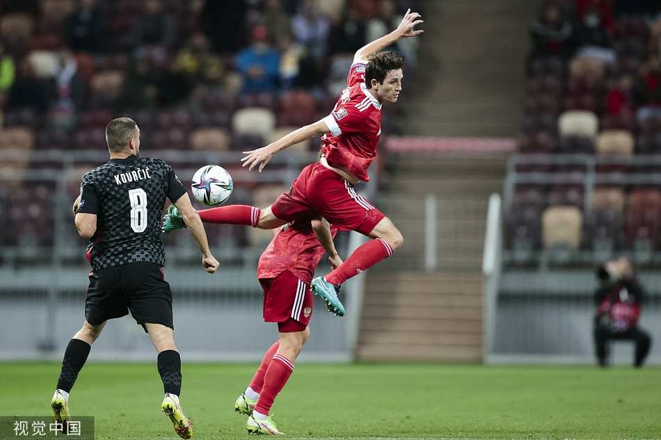 克罗地亚中场大将布罗佐维奇与俄罗斯悍将伊诺夫在草坪上激烈拼抢，球衣拉扯间肌肉线条分明，战斗意志在脚下燃烧