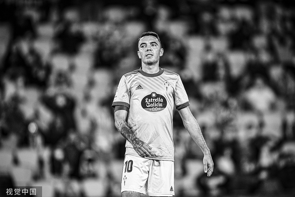 塞尔塔前锋阿斯帕斯在对方禁区内奋力跃起，与格拉纳达防守球员争抢头球。他坚毅的眼神和舒展的身体姿态，透露出对进球的极度渴望，即便面对多人包夹也毫不退让。