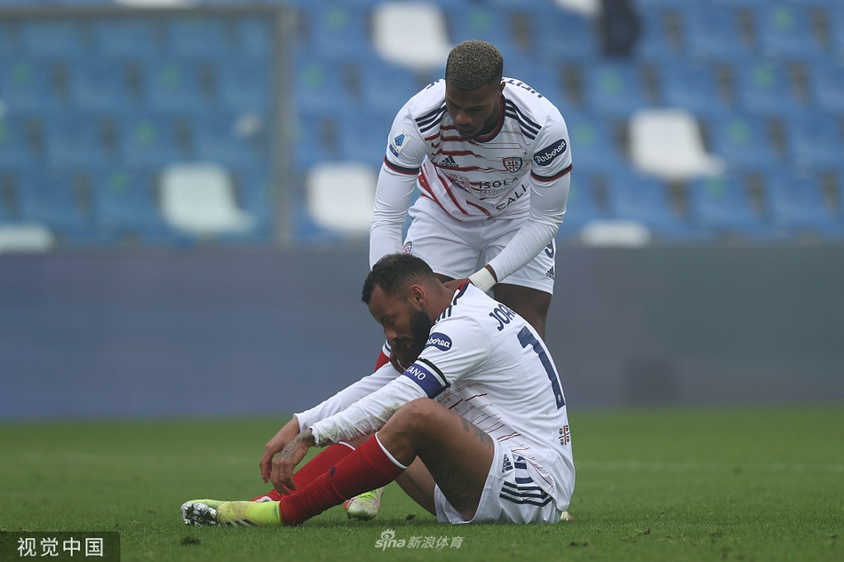 卡利亚里门将克拉尼奥在对方前锋的逼抢下，依然冷静地用脚将球解围，他的表情写满了专注与坚决。