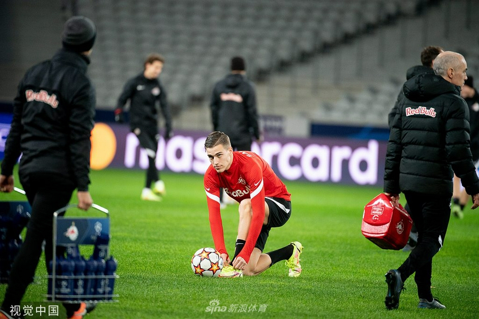 球员们排成两列进行折返跑训练，带起的草屑在空中飞舞，所有人表情坚毅，整个画面充满了动感和力量感