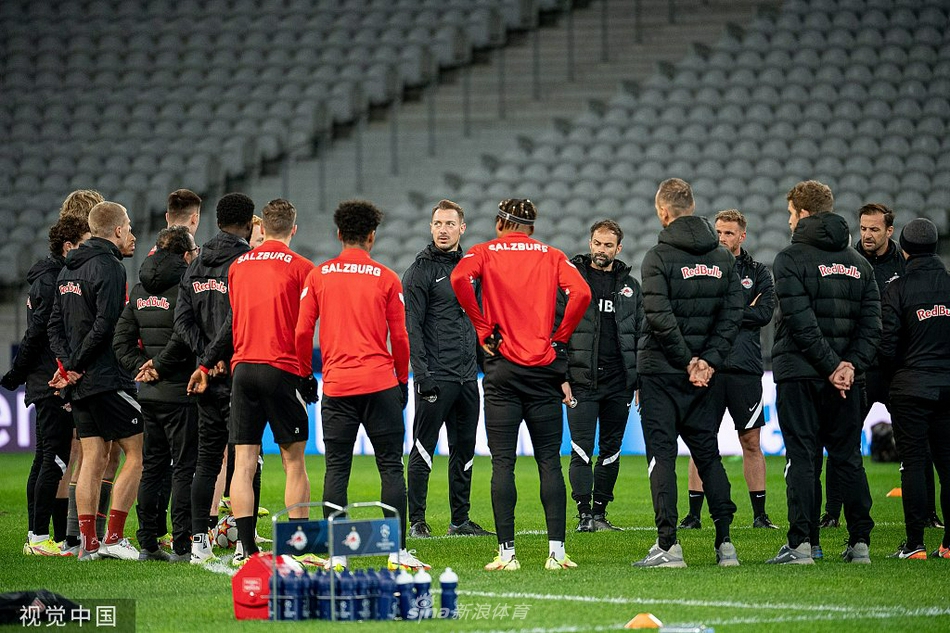 两名红牛球员正在进行传接球配合，红色的身影在绿色的草坪上格外显眼，皮球在两人之间快速滚动，展现出他们娴熟的脚下技术