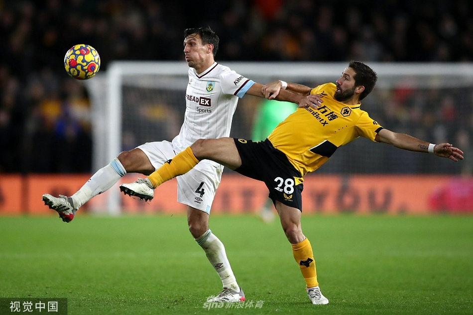 伯恩利高中锋克里斯·伍德在狼队禁区内高高跃起，与对方后卫考迪进行激烈的空中争顶，彰显英超传统对抗