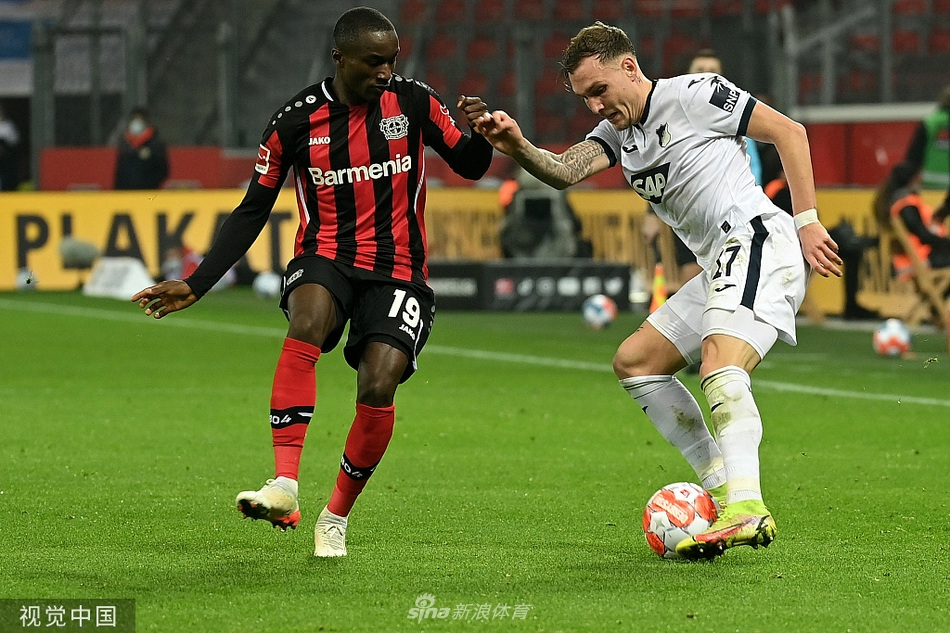 勒沃库森飞翼迪亚比带球快速突破，霍芬海姆后卫劳姆紧追不舍，上演速度与技巧的追逐战。