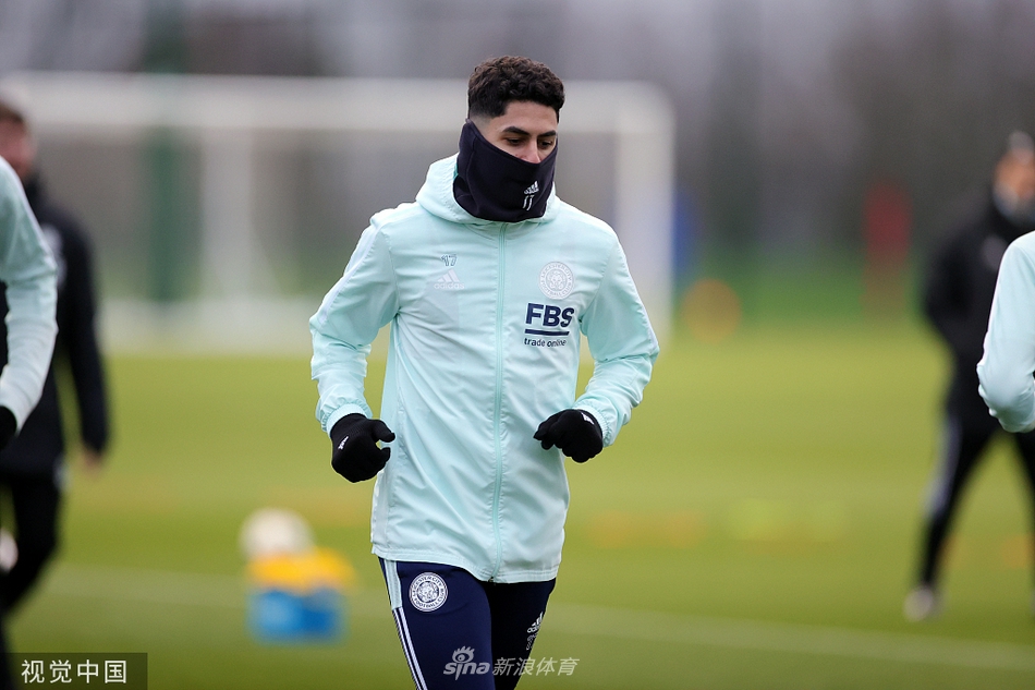 主教练罗杰斯手持战术板，向围聚的球员们激情讲解比赛策略