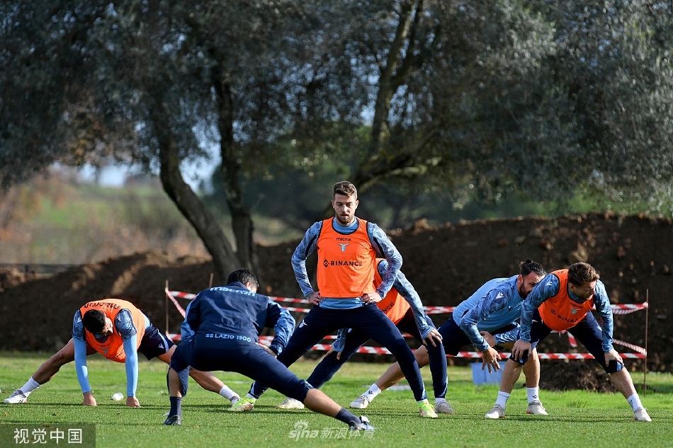 两名拉齐奥球员在训练中进行高强度一对一攻防演练，进攻方试图突破，防守方则压低重心紧盯皮球，气氛紧张激烈。