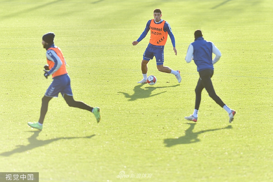 中后卫迈克尔·基恩与年轻队友在对抗赛中紧密协作，用一记精准的滑铲将球破坏，展现出防线默契。