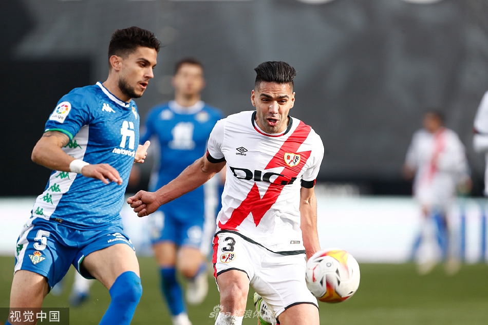 巴列卡诺前锋如闪电般突入贝蒂斯禁区，防守球员奋力回追，球场灯光聚焦于这电光火石的瞬间。