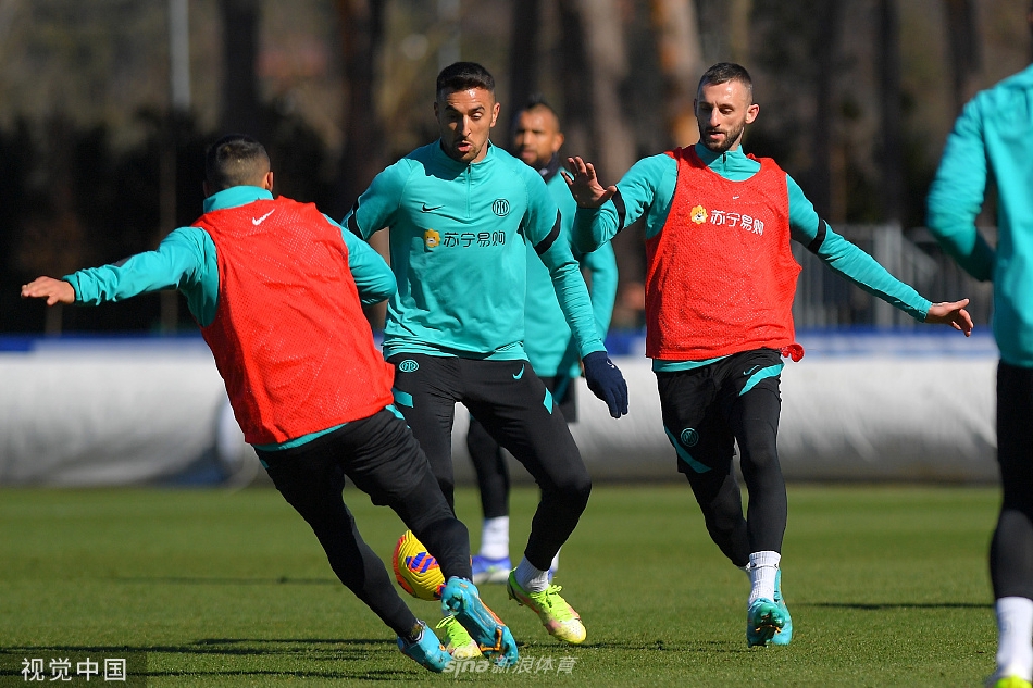 球员围成一圈进行拉伸热身，蓝天白云下绿草如茵