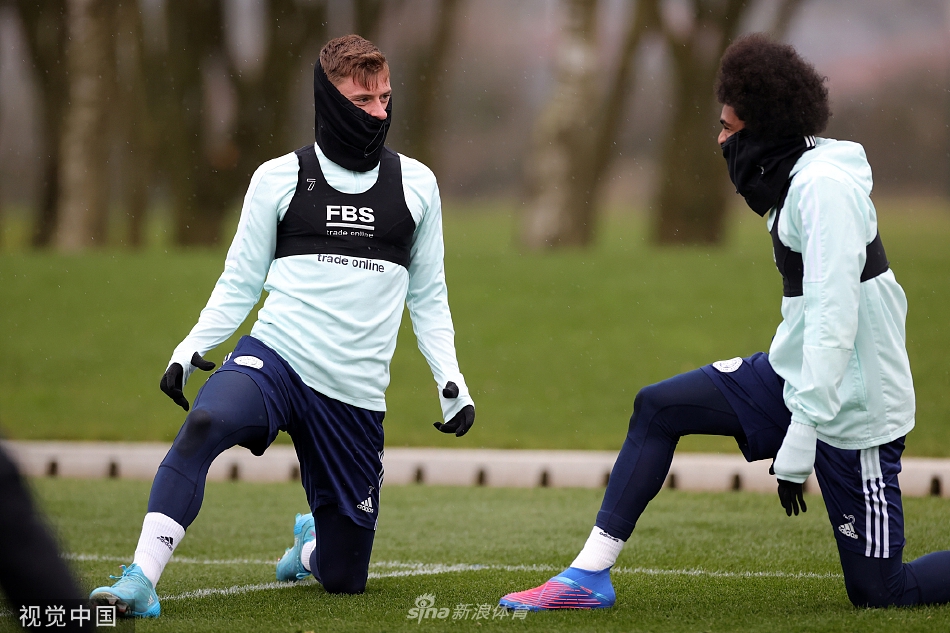 主教练布伦丹·罗杰斯神情专注地站在训练场中央，手持战术板，正在向围拢的队员们详细讲解即将到来的比赛战术部署。