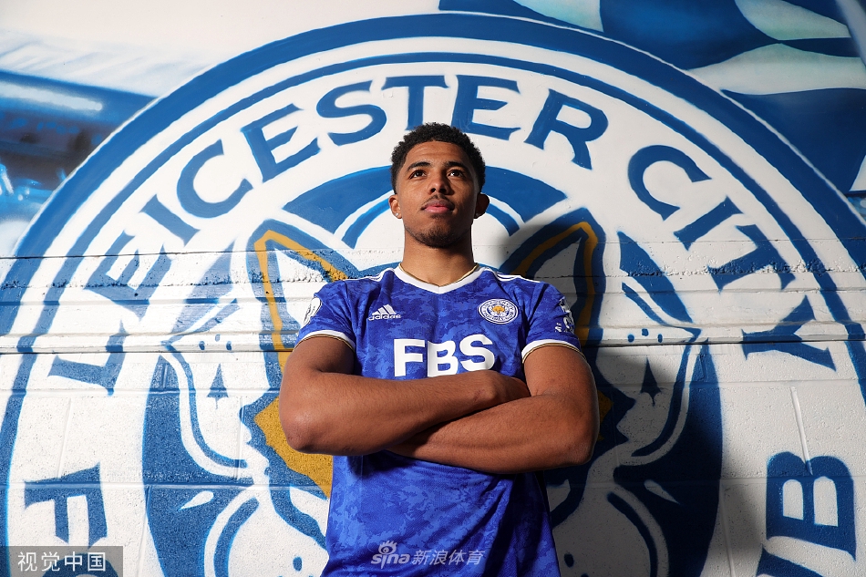 韦斯利·福法纳手持莱斯特城球衣，面带坚定而充满希望的笑容，在新合同旁郑重签下自己的名字。