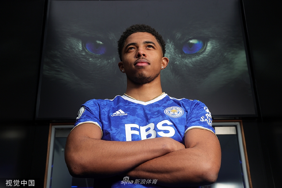 福法纳与俱乐部官员在签约后亲切握手，背景是莱斯特城队徽，象征着信任与未来的正式缔结。