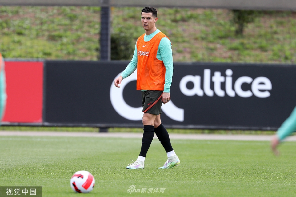 C罗与队友若昂·坎塞洛在训练间隙并肩行走交流，两人面带微笑气氛轻松，展现了更衣室的良好氛围。