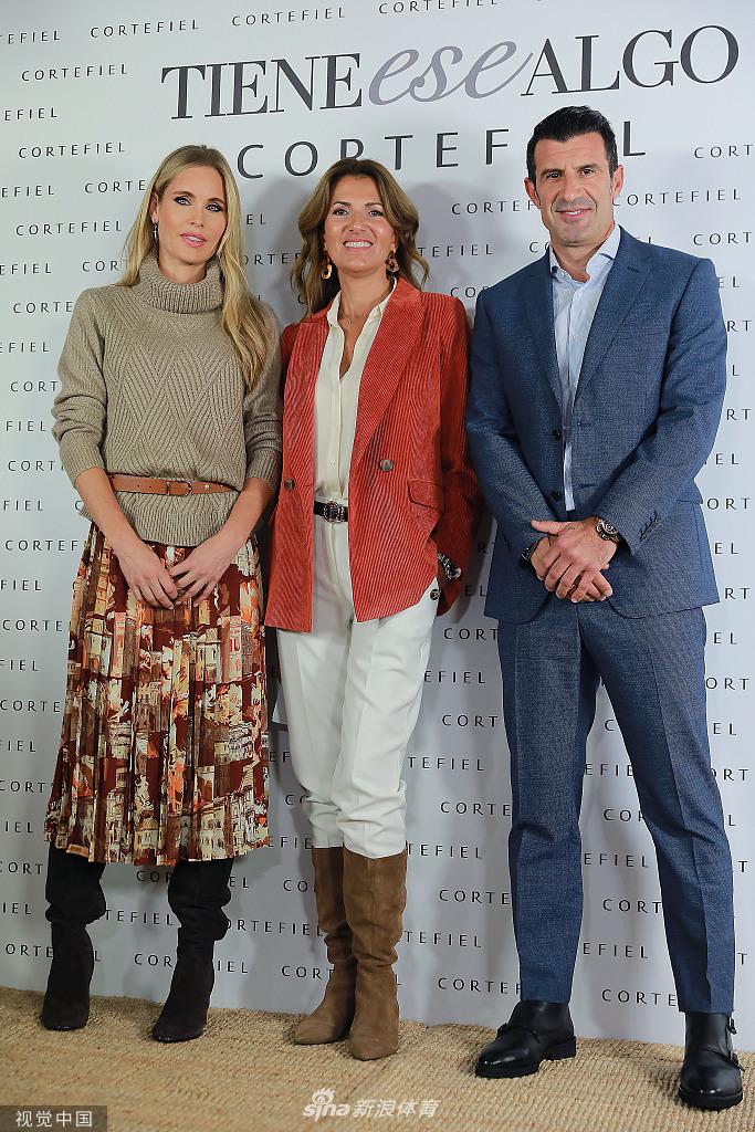 菲戈与爱妻海伦在闪光灯下相视而笑，他一身深色西装尽显绅士风度，她则身着优雅长裙，岁月沉淀的默契在眼神中流转。